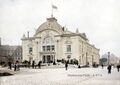 Das Stadttheater auf einer alten Photographie noch mit Rondell, links daneben die Brauerei Geismann (Kolorierung mit <a rel="nofollow" class="external text" href="https://www.myheritage.de/incolor">MyHeritage in Color (tm)</a>)