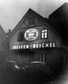 Reifen-Reichel bei Nacht mit Leuchtreklame an der Fassade, ca. 1960