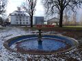 Brunnen unweit des Quelltempels der König-Ludwig-Quelle I auf dem Gelände der heutigen <!--LINK'" 0:2-->, im Hintergrund das <!--LINK'" 0:3-->, Januar 2021