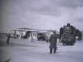 Ein Güterzug quert die <!--LINK'" 0:26--> mit zwei Streckenposten (1950er Jahre)