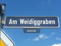 Straßenschild Am Weidiggraben mit Erläuterung